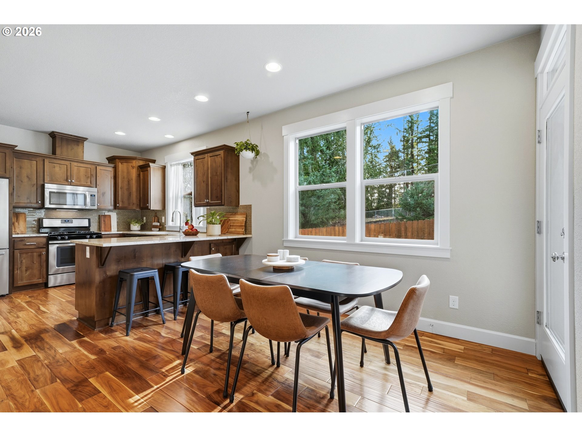 17390 Aubin Street Sandy, OR 97055 - Photo 14 of 41 a kitchen with stainless steel appliances granite countertop a table chairs refrigerator and cabinets