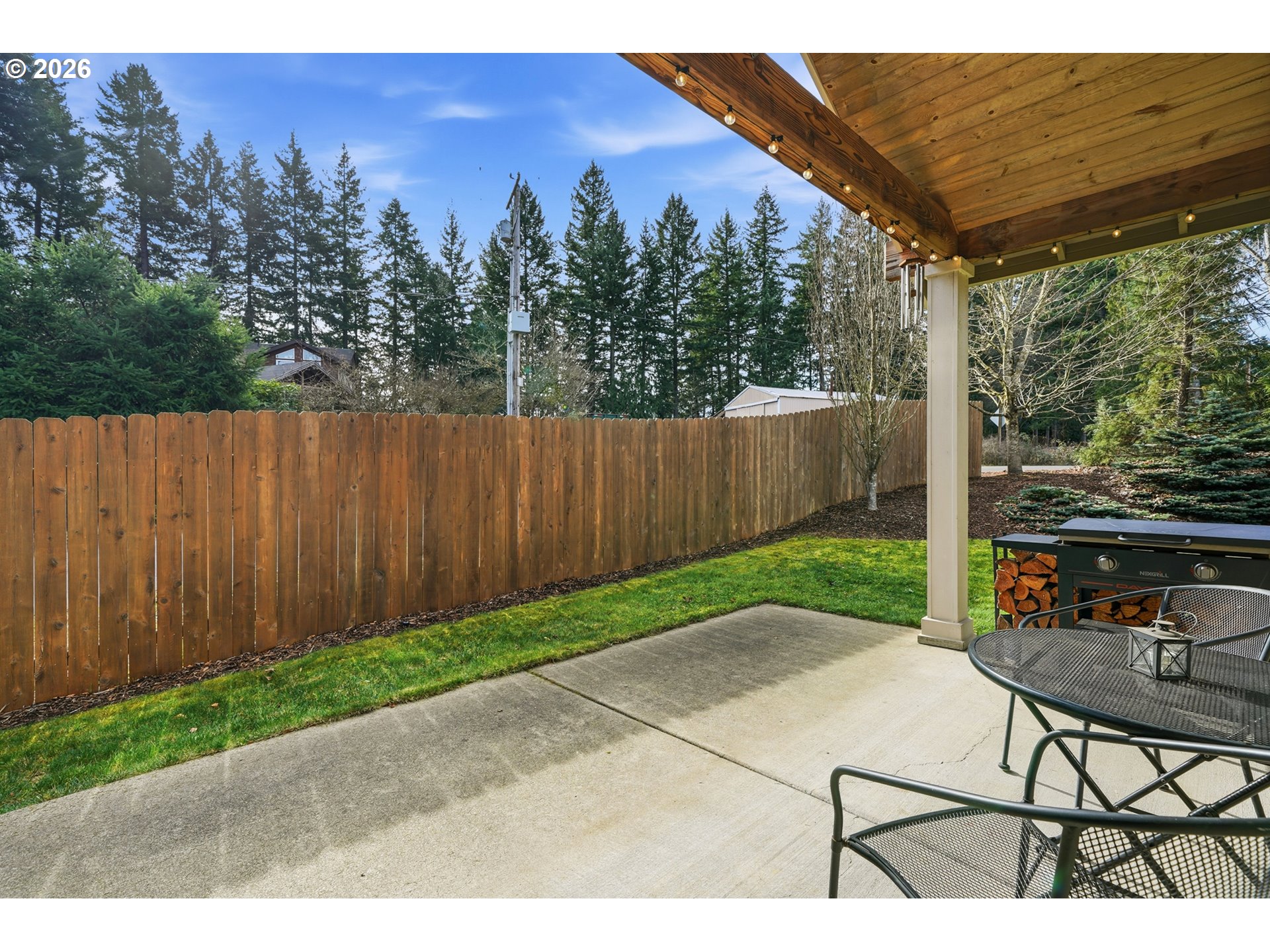17390 Aubin Street Sandy, OR 97055 - Photo 34 of 41 a view of a backyard with table and chairs with wooden fence