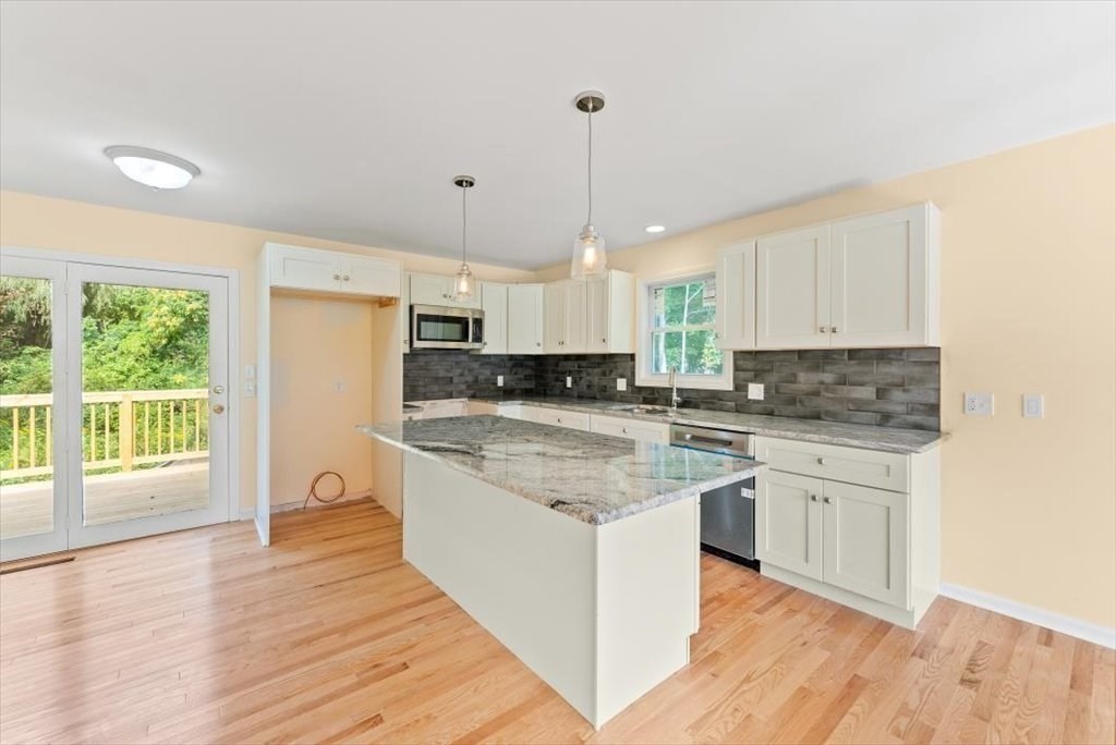 1893 Allen Street Springfield, MA 01128 - Photo 7 of 25 a large kitchen with stainless steel appliances granite countertop a stove a sink dishwasher a refrigerator and white cabinets with wooden floor