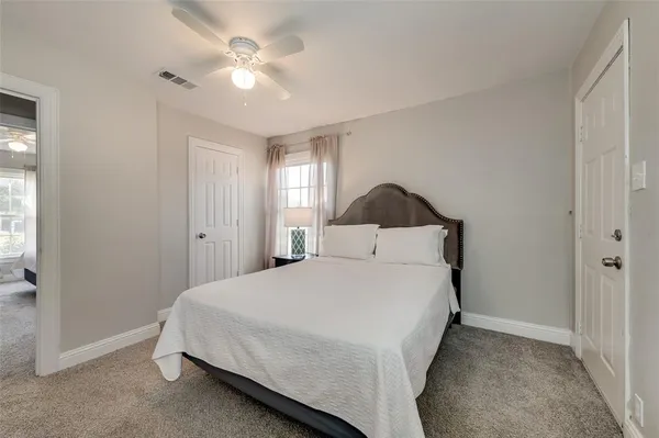 a bedroom with a bed and a ceiling fan