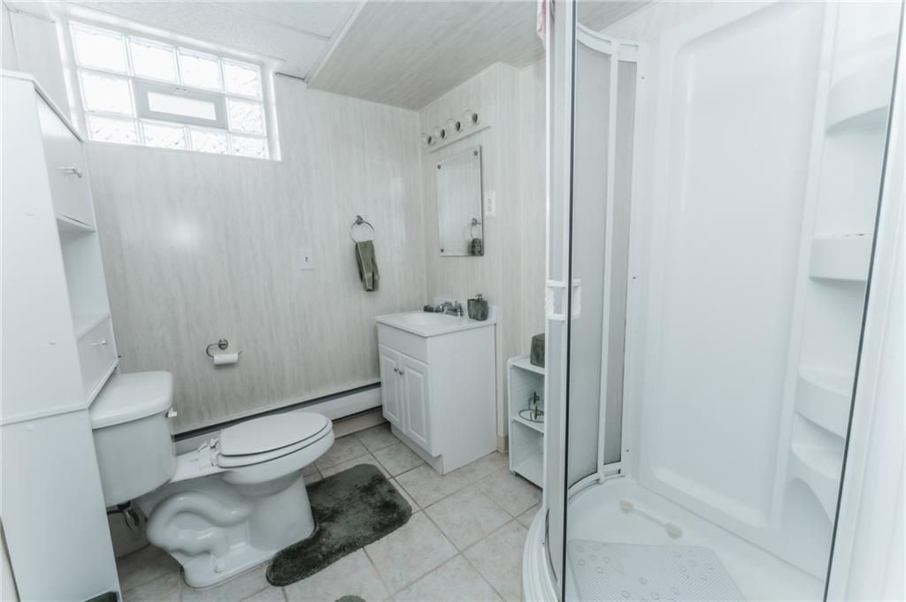 1061 Martin Road Tarentum, PA 15084 - Photo 17 of 25 a white toilet sitting next to a bathroom sink and a shower