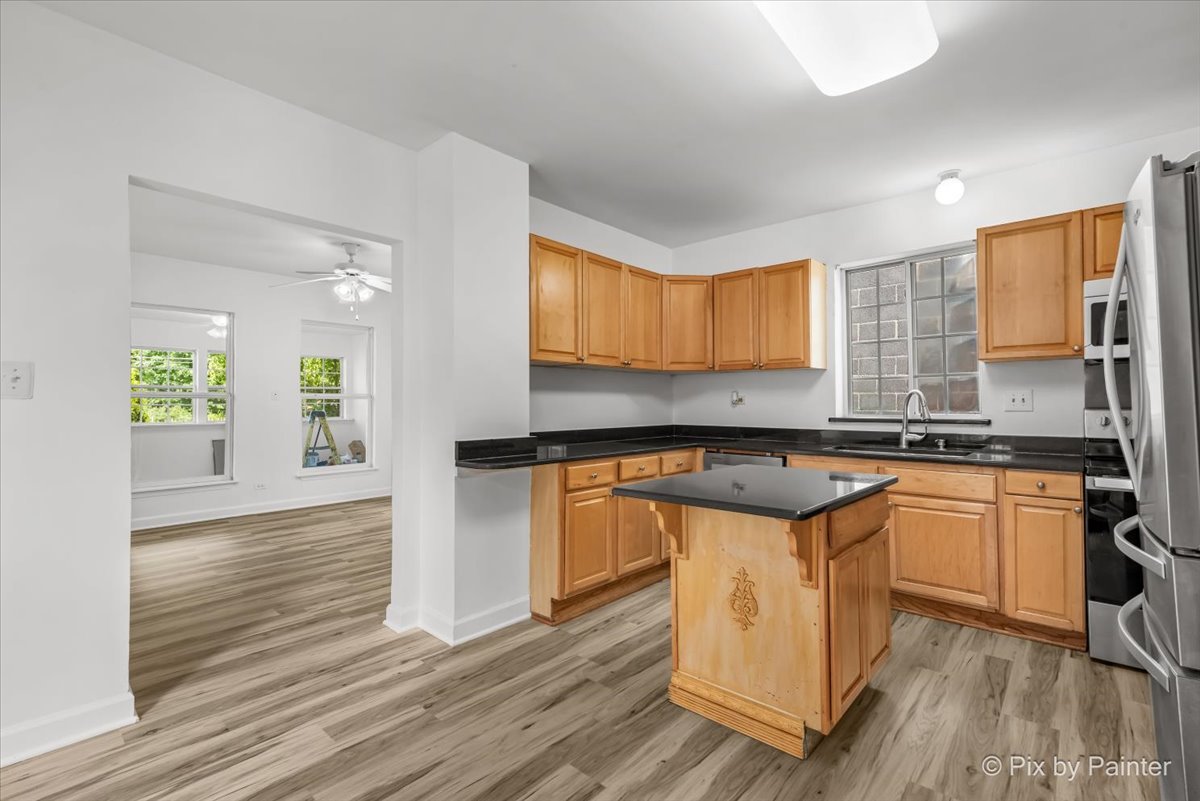 309 Griswold Street Elgin, IL 60123 - Photo 13 of 39 a kitchen with stainless steel appliances granite countertop wooden cabinets a sink a stove a dining table and chairs