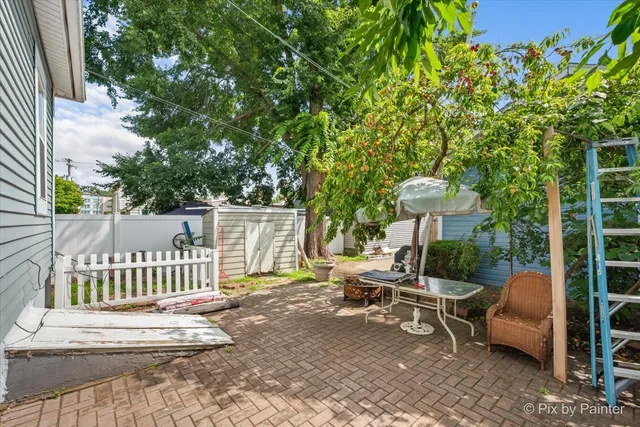 a view of a chair and tables in the back yard of the house