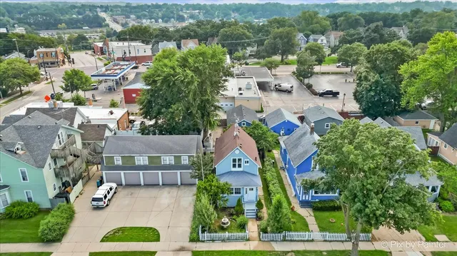 an aerial view of residential houses with outdoor space and parking
