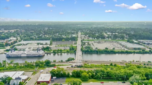 an aerial view of lake and residential houses with outdoor space and swimming pool