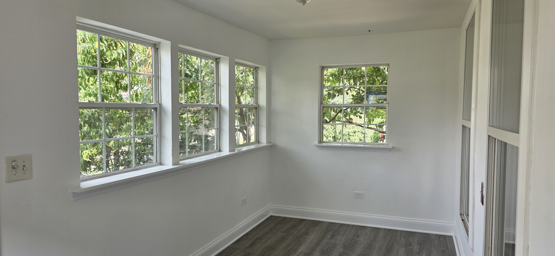 309 Griswold Street Elgin, IL 60123 - Photo 4 of 39 a view of an empty room with wooden floor and windows