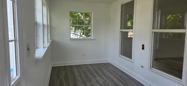 a view of a hallway with wooden floor and entryway