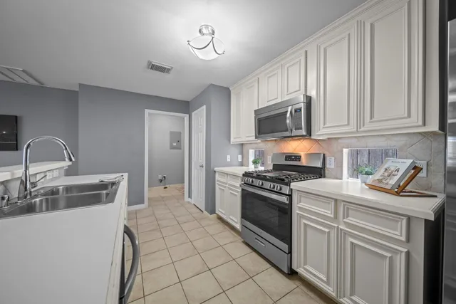 a kitchen with cabinets appliances and a sink