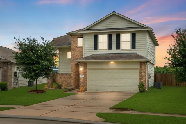 a front view of a house with a yard and garage