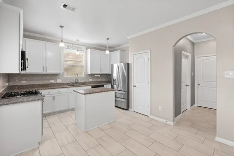 a kitchen with a refrigerator sink and cabinets