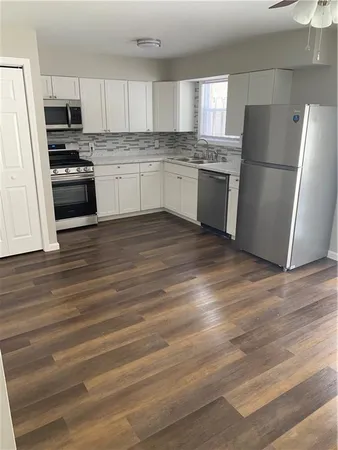a kitchen with stainless steel appliances a refrigerator sink and microwave