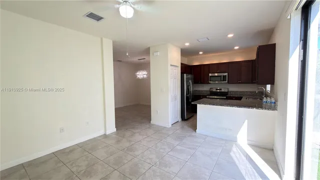 a view of kitchen with stainless steel appliances a refrigerator and a stove top oven