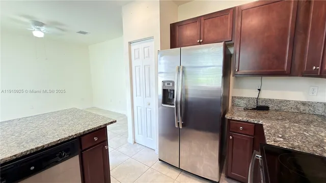 a kitchen with stainless steel appliances granite countertop a refrigerator and a sink