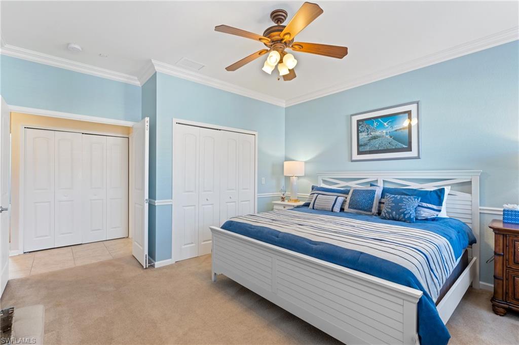 10057 Via Colomba Circle, Unit 206 Fort Myers, FL 33966 - Photo 37 of 46 a bedroom with bed and a chandelier