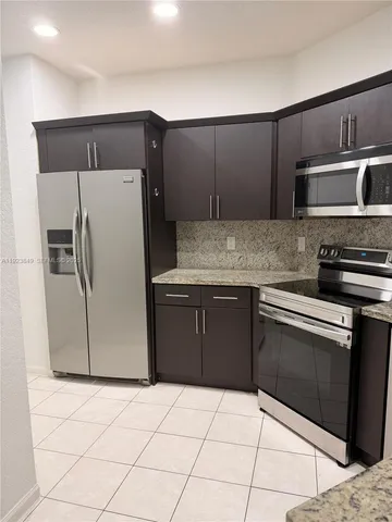 a kitchen with stainless steel appliances a refrigerator sink and microwave