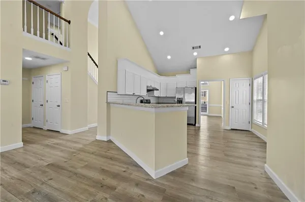 a view of kitchen with kitchen island white cabinets and stainless steel appliances