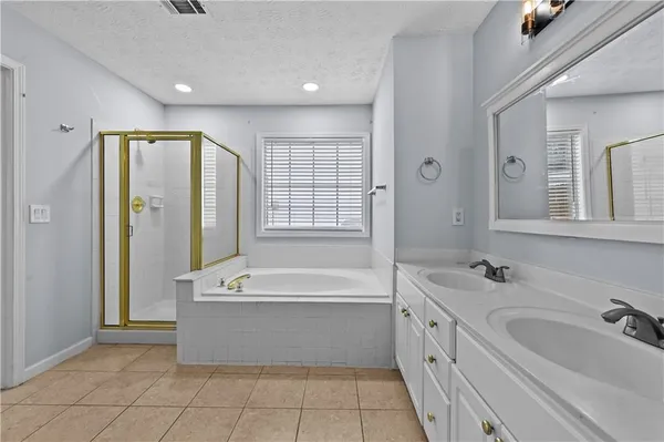 a spacious bathroom with a tub sink and mirror