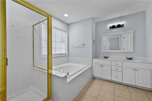a bathroom with a tub sink and mirror