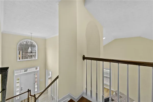 a view of staircase with railing and white walls