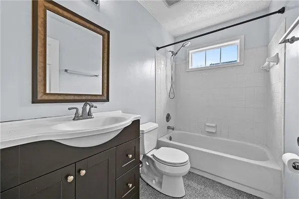 a bathroom with a toilet a sink a mirror and a bathtub