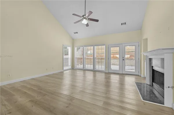 a view of an empty room with a fireplace and a window