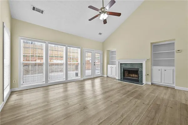 a view of empty room with wooden floor and fireplace