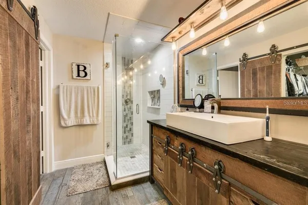 a bathroom with a double vanity sink a mirror and shower