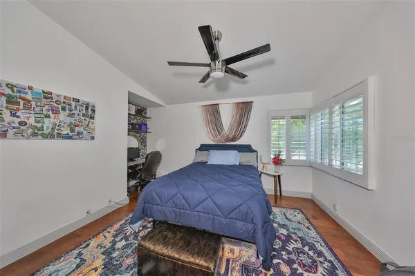 a bedroom with a bed a chandelier and a window