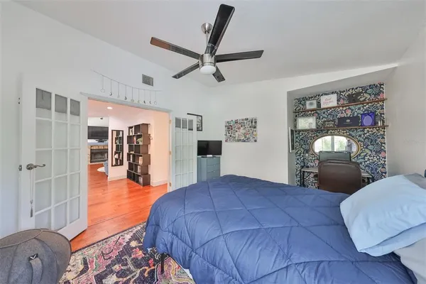 a bedroom with a large bed and a chandelier