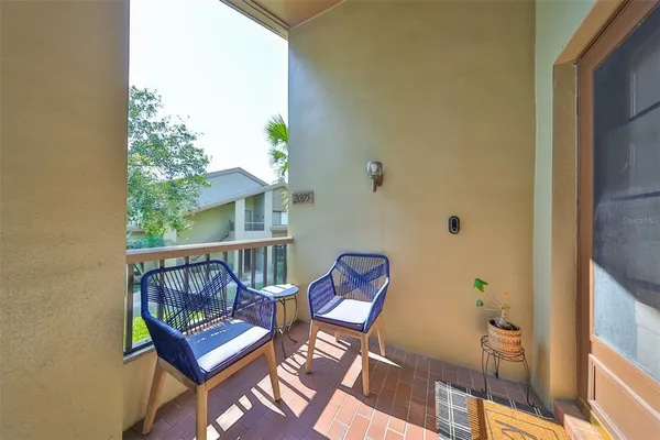 a view of balcony with wooden floor outdoor seating and yard in the back