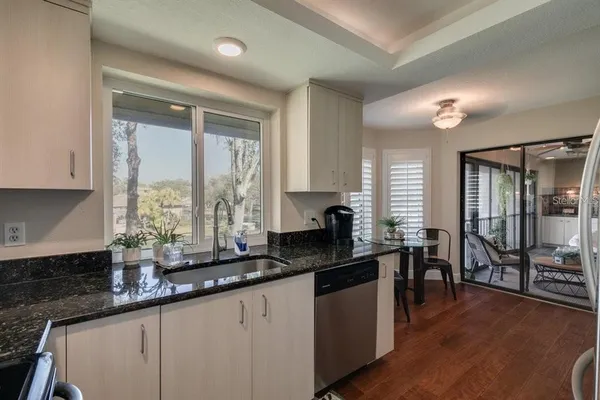 a kitchen with granite countertop a large window cabinets and stainless steel appliances