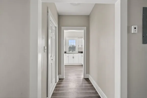 a view of a hallway with wooden floor