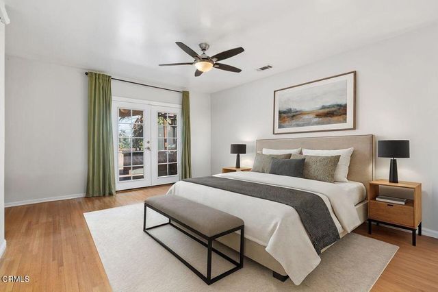 a spacious bedroom with a bed and wooden floor
