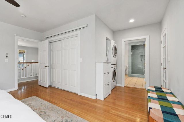 a view of a hallway with wooden floor and cabinet