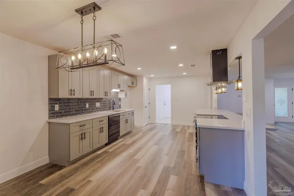 a large kitchen with stainless steel appliances granite countertop a stove oven and a white refrigerator