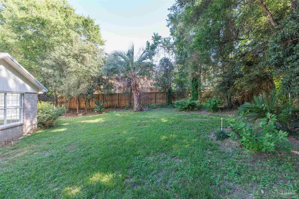 a view of a house with backyard and tree