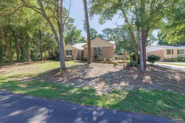 a front view of a house with a yard and trees