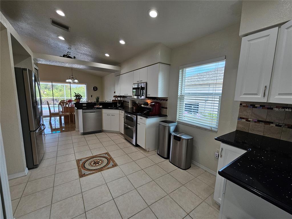 114 Albatross Road Rotonda West, FL 33947 - Photo 12 of 36 a kitchen with a refrigerator a sink a stove and cabinets