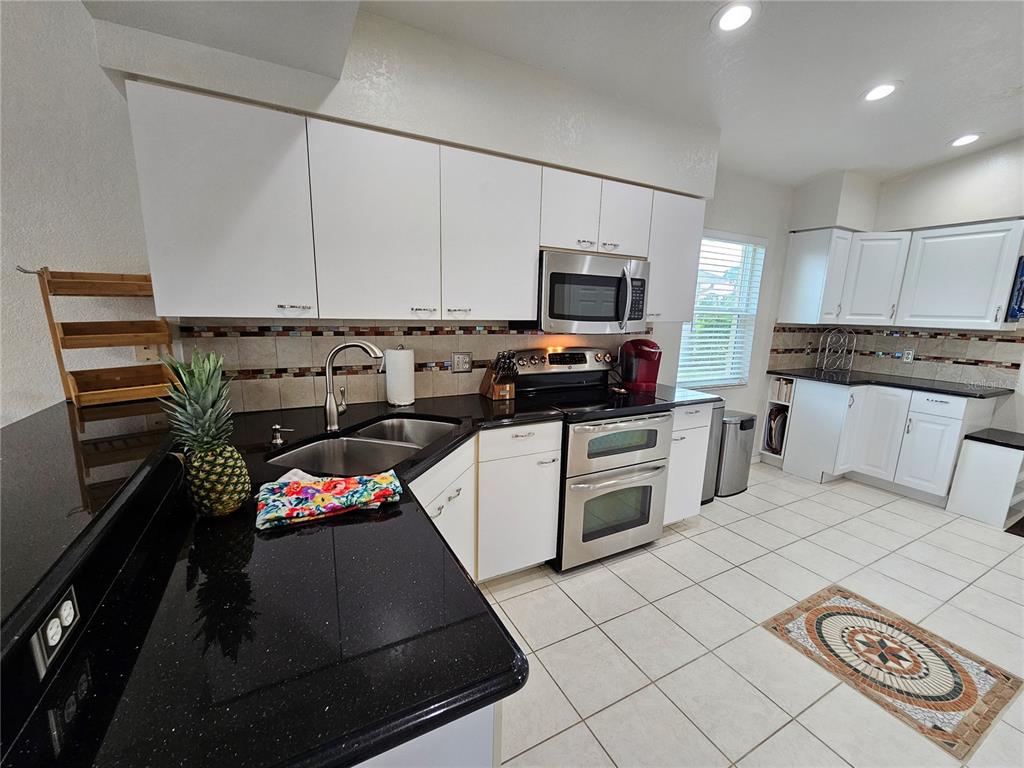 114 Albatross Road Rotonda West, FL 33947 - Photo 15 of 36 a kitchen with a sink a stove and cabinets