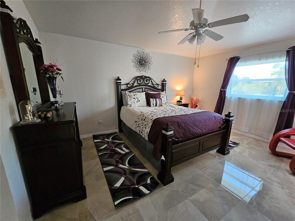114 Albatross Road Rotonda West, FL 33947 - Photo 17 of 36 a bedroom with a bed and a mirror on the dresser