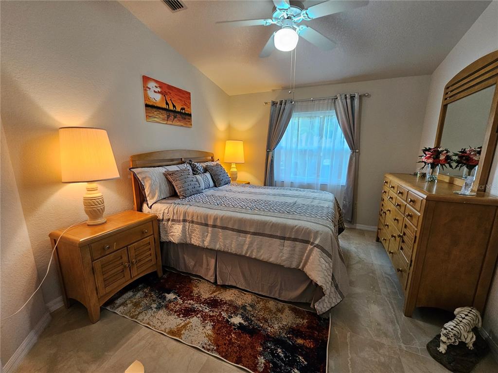 114 Albatross Road Rotonda West, FL 33947 - Photo 23 of 36 a bedroom with a bed table and chair