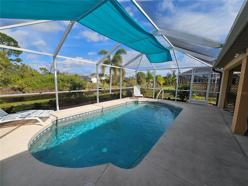 114 Albatross Road Rotonda West, FL 33947 - Photo 30 of 36 a view of a patio with a table and chairs under an umbrella