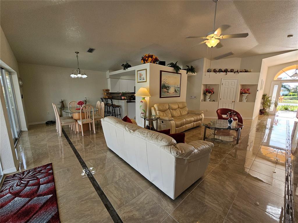 114 Albatross Road Rotonda West, FL 33947 - Photo 8 of 36 a living room with furniture and a chandelier