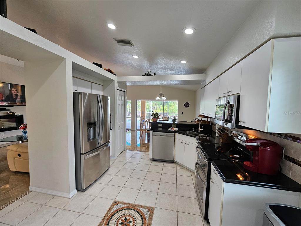 114 Albatross Road Rotonda West, FL 33947 - Photo 9 of 36 a kitchen with refrigerator and cabinets
