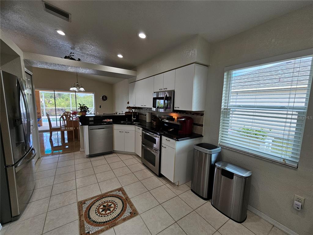 114 Albatross Road Rotonda West, FL 33947 - Photo 10 of 36 a kitchen with a sink a counter top space stainless steel appliances and cabinets