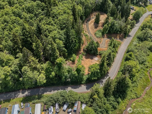 an aerial view of residential house with outdoor space and trees all around
