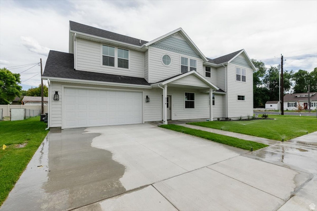View of front facade featuring concrete driveway, an attached garage, and roof with shingles