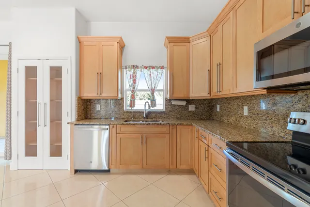 a kitchen with stainless steel appliances granite countertop a sink and a stove