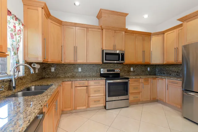 a kitchen with stainless steel appliances granite countertop a sink and a microwave