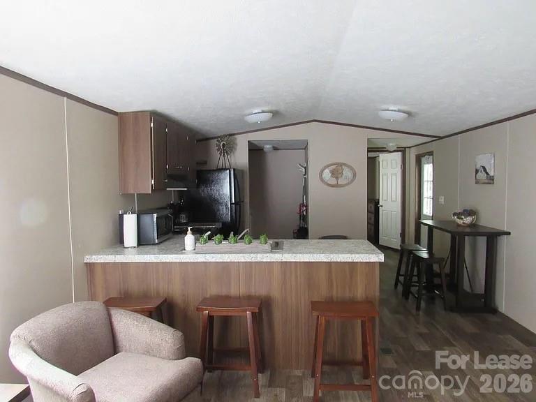 3298 Pea Ridge Road Mill Spring, NC 28756 - Photo 2 of 7 a kitchen with stainless steel appliances kitchen island granite countertop a refrigerator a stove a oven with white cabinets and wooden floor